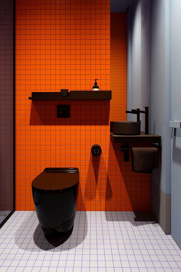 Phòng tắm nổi bật với gạch lát màu cam hút mắt. 