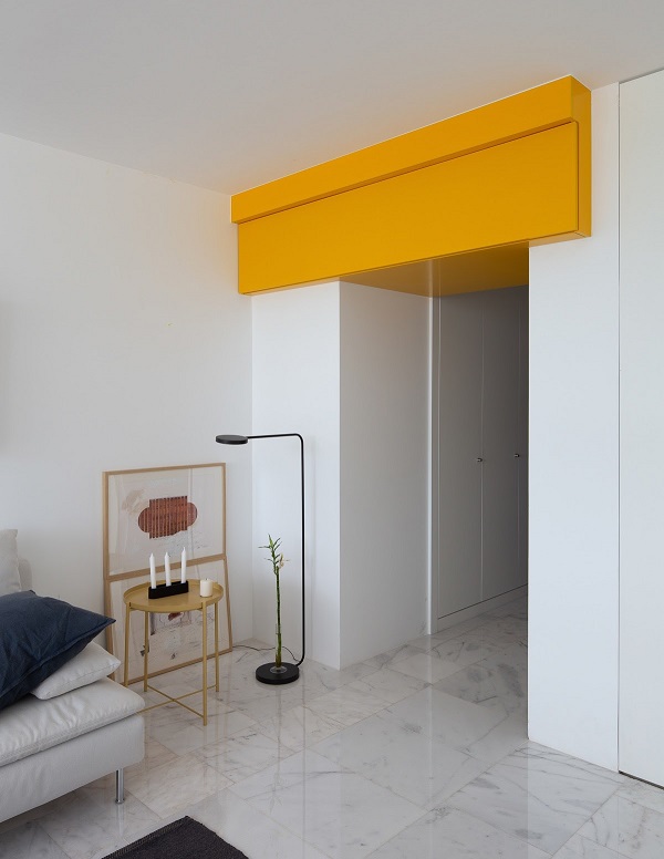 Trên cửa là một tấm ốp màu vàng, liên kết màu sắc căn hộ. 