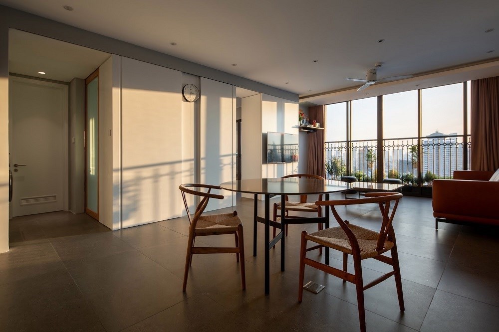 Bàn ăn gọn gàng, đơn giản. Lan can rộng mở, tràn ngập ánh sáng